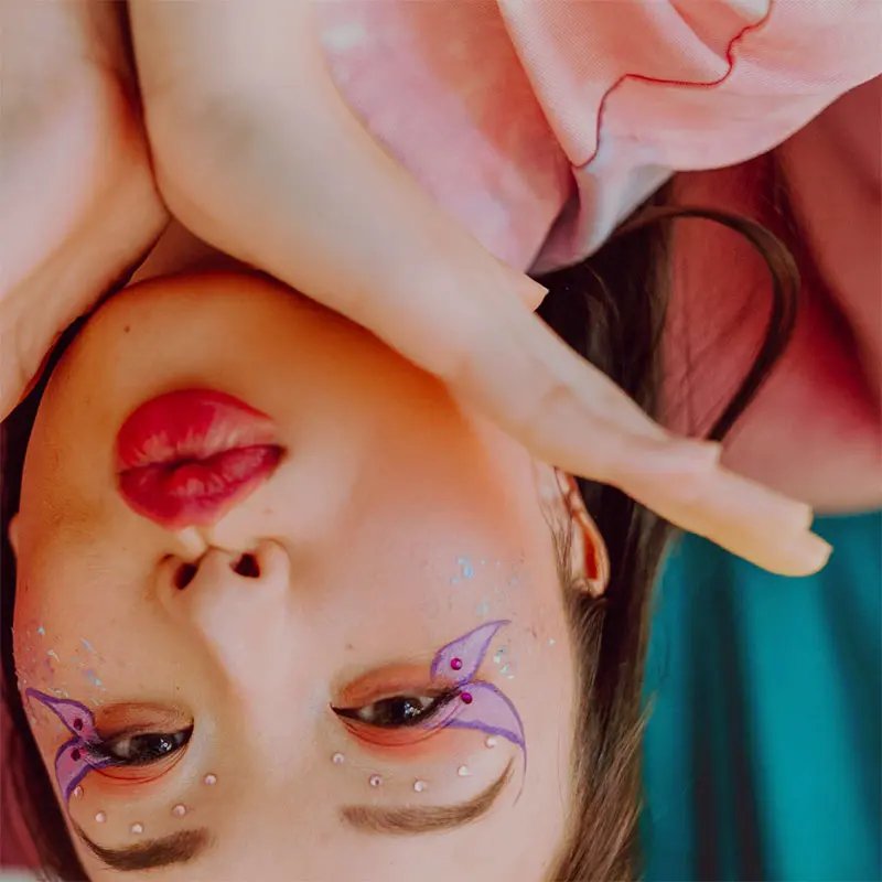 Young woman with fancy make-up upside down
